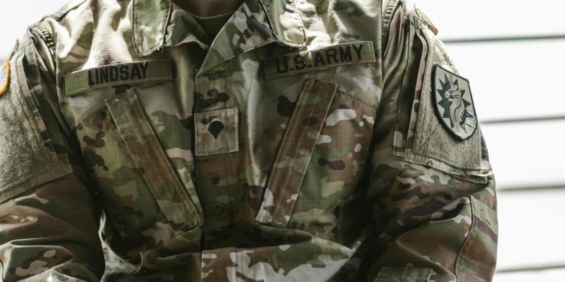 Detailed view of a U.S. Army soldier's camouflage uniform with insignia and name tags visible.