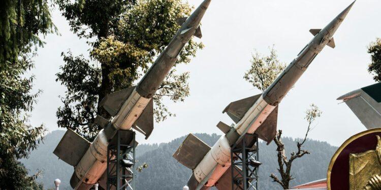a row of military missiles on display behind a fence