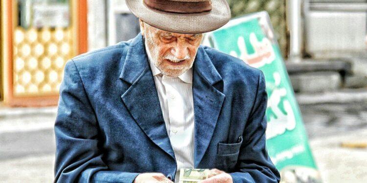 a man in a hat holding a glass of beer