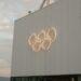 White building with illuminated olympic rings symbol
